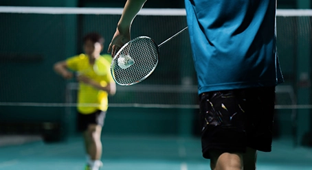 Two men playing badminton on a court, highlighting the vibrant community at Nyati Emerald in Baner.