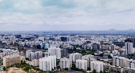 A vibrant city skyline featuring numerous buildings under a clear sky, highlighting the strategic location of Nyati Emerald in Baner.