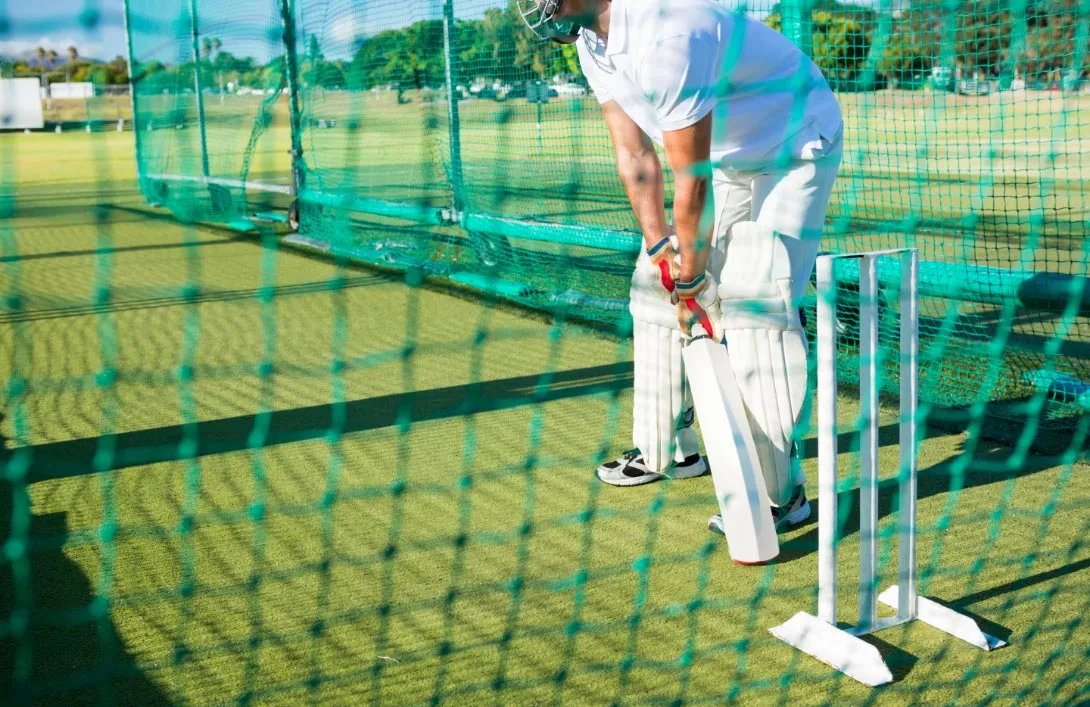 player in white shirt practices in net at Nyati-Elite, Premium flats with Net Cricket facility
